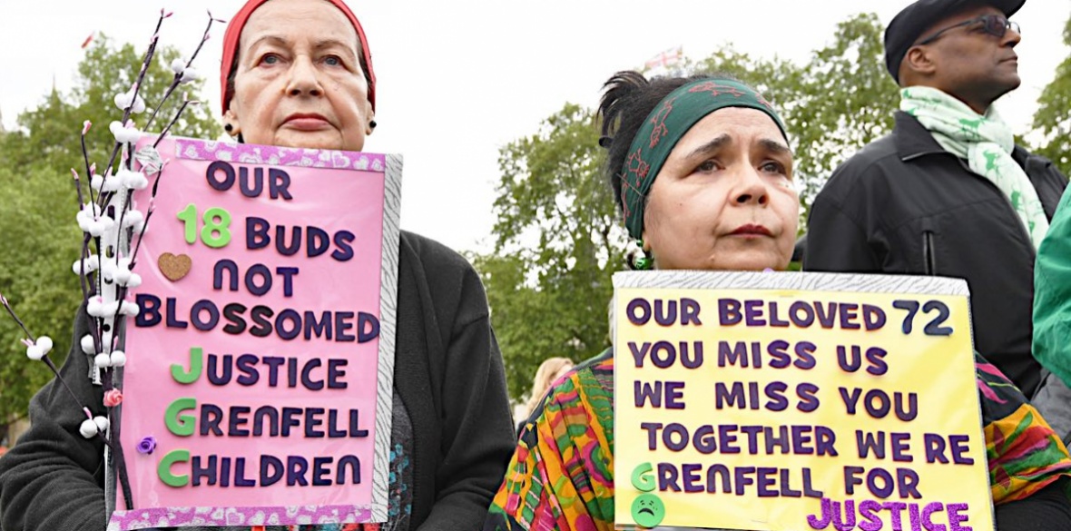 People hold placards at a Grenfell justice protest outside the British parliament on May 14 2018. Photo: John Stillwell/PA Wire