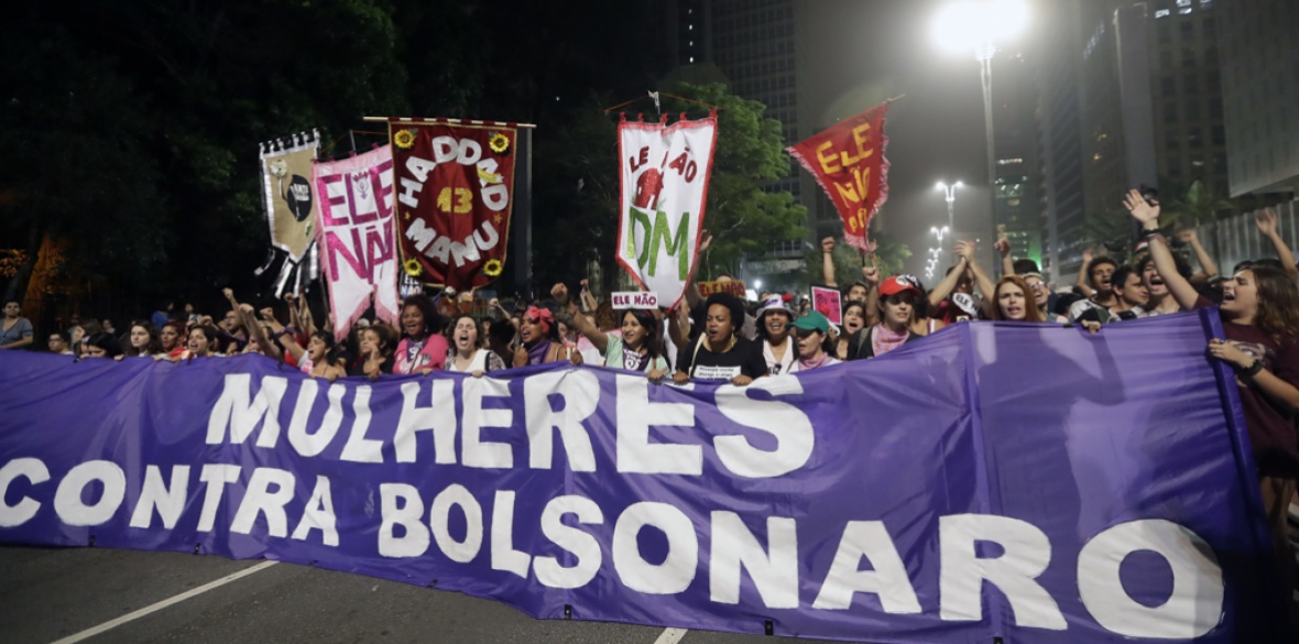 Women march holding a banner that reads in Portuguese: 'Women against Bolsonaro' during a protest against far-right presidential candidate Jair Bolsonaro on Saturday