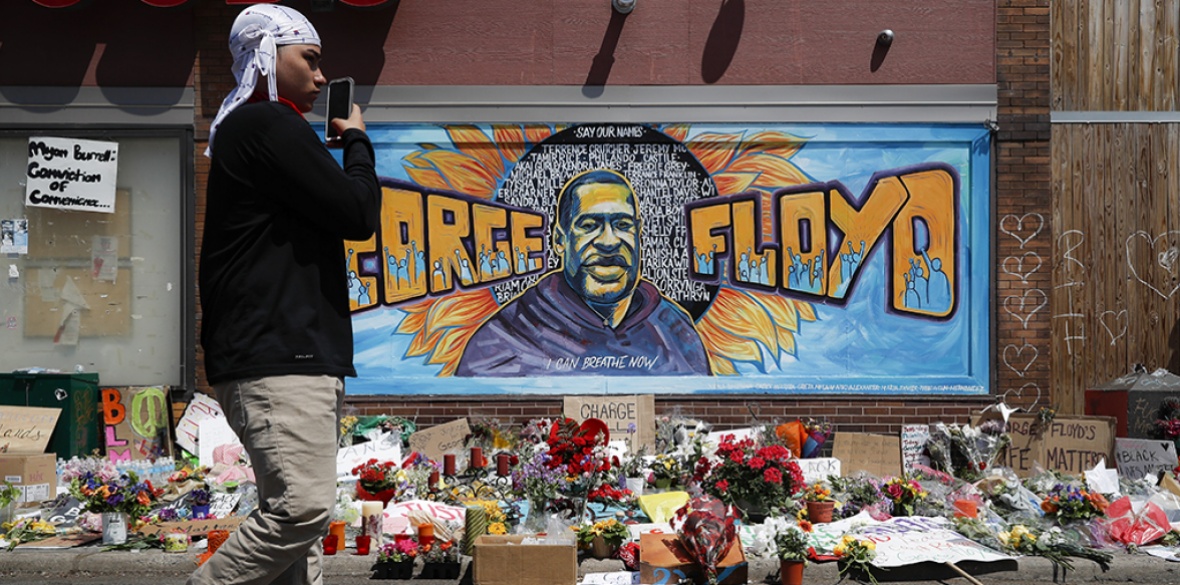 Mourners gather to place flowers at a makeshift memorial for George Floyd at the corner of Chicago Avenue and East 38th Street in Minneapolis in the USA