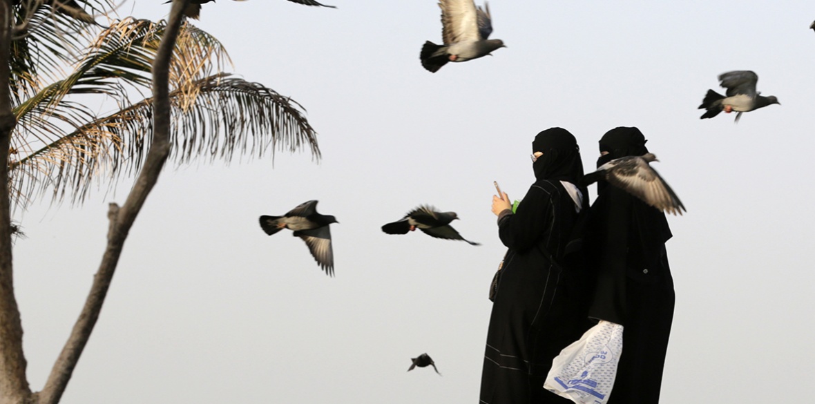 Saudi women film pigeons at a public garden in Jiddah