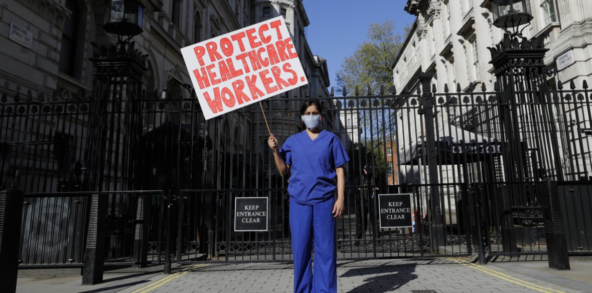 Doctor Meenal Viz holds a banner as she protests outside Downing Street in London, on Sunday