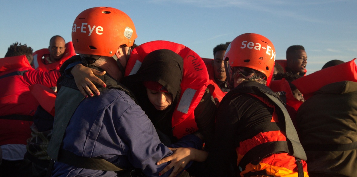 Sea Eye's crew pull refugees from an unseaworthy boat in the central Mediterranean