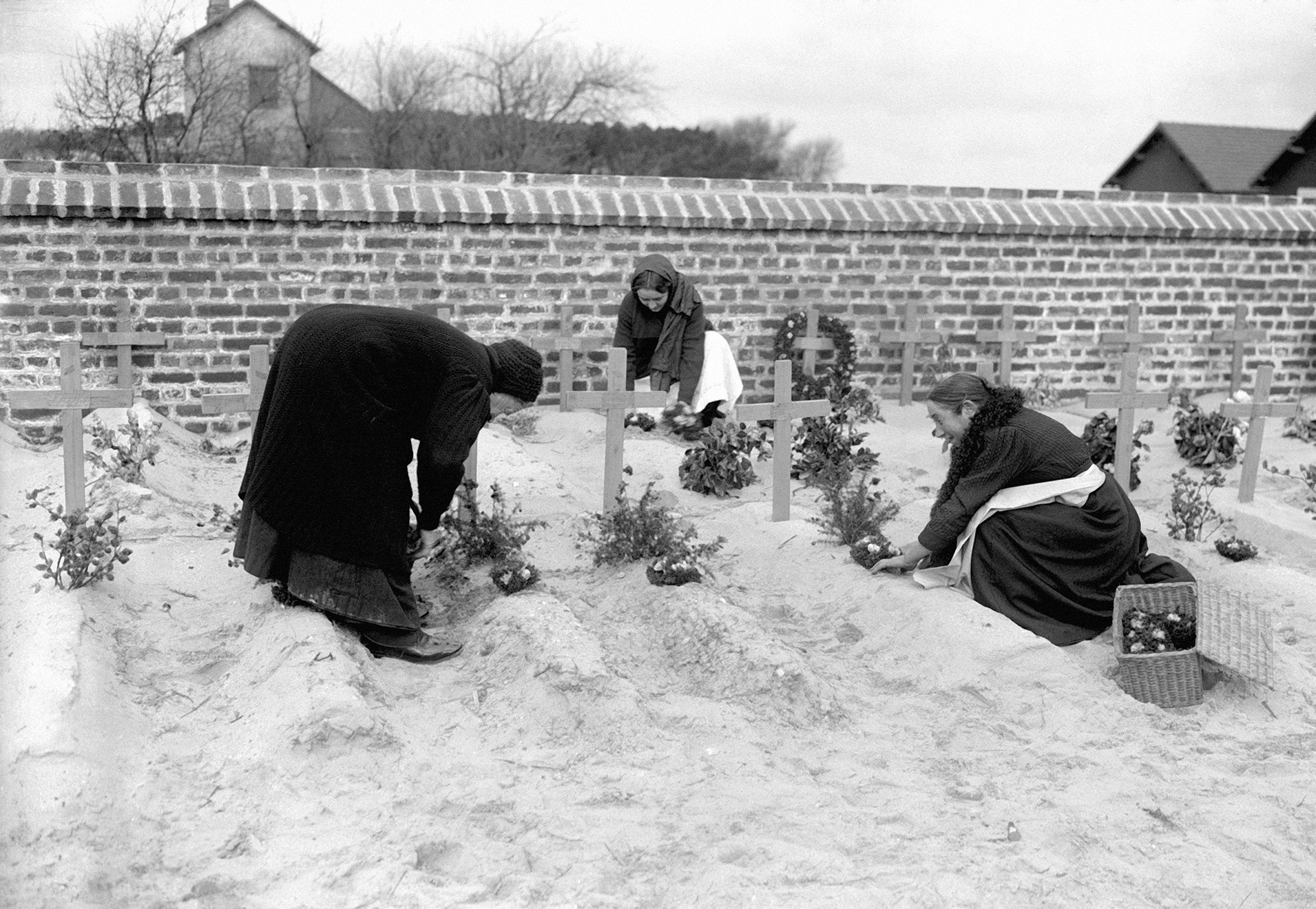 Belgian peasant women plant flowers on the graves of British soldiers in Belgium