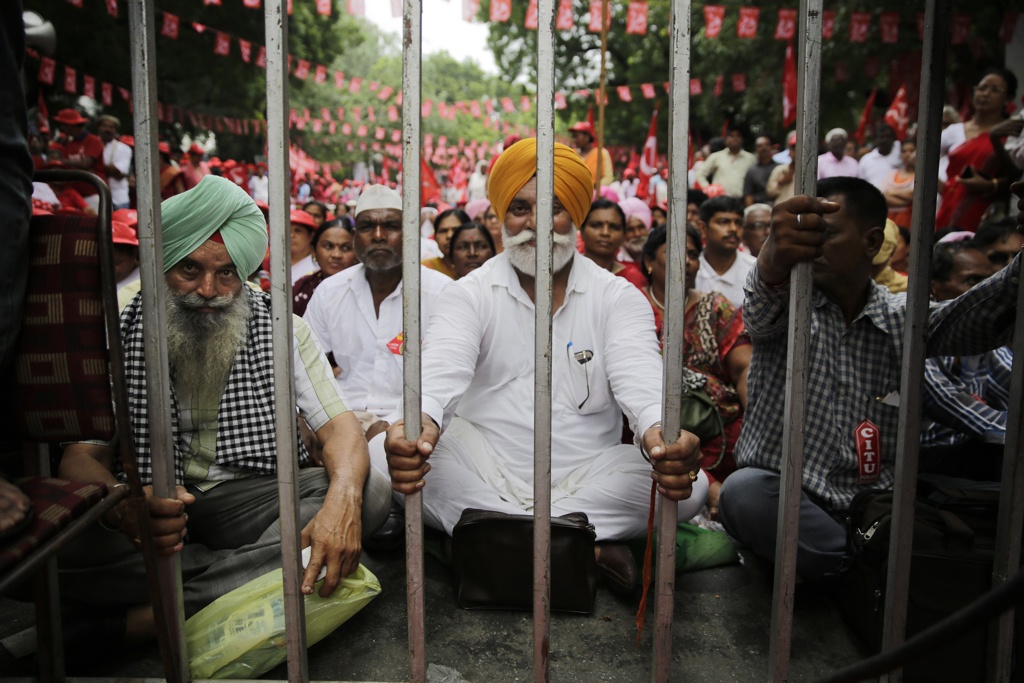 Protesters sit behind a barricade as they listen to a speaker