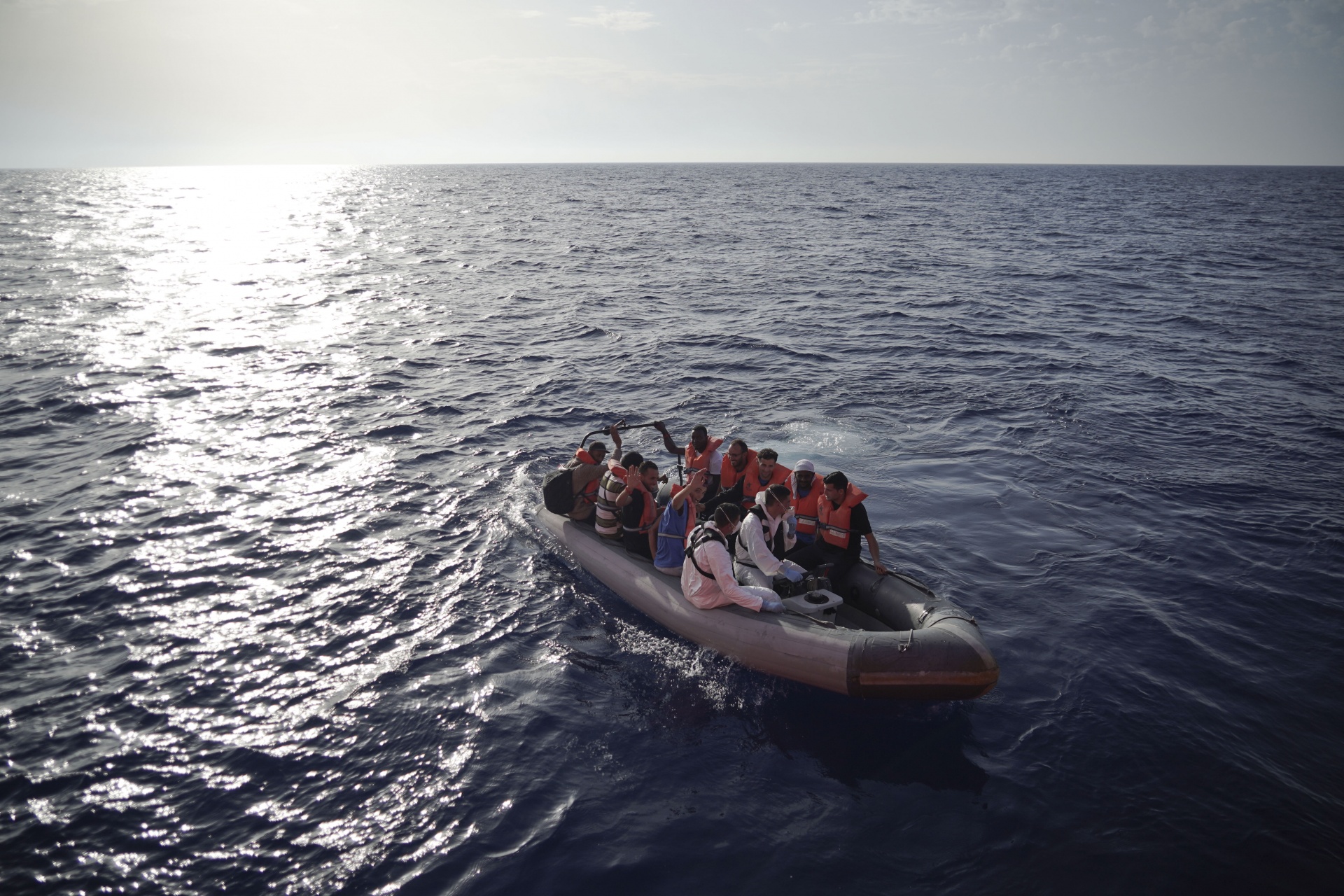 Members of the Maltese Armed Forces take a group of migrants to a Maltese military ship in the Mediterranean Sea