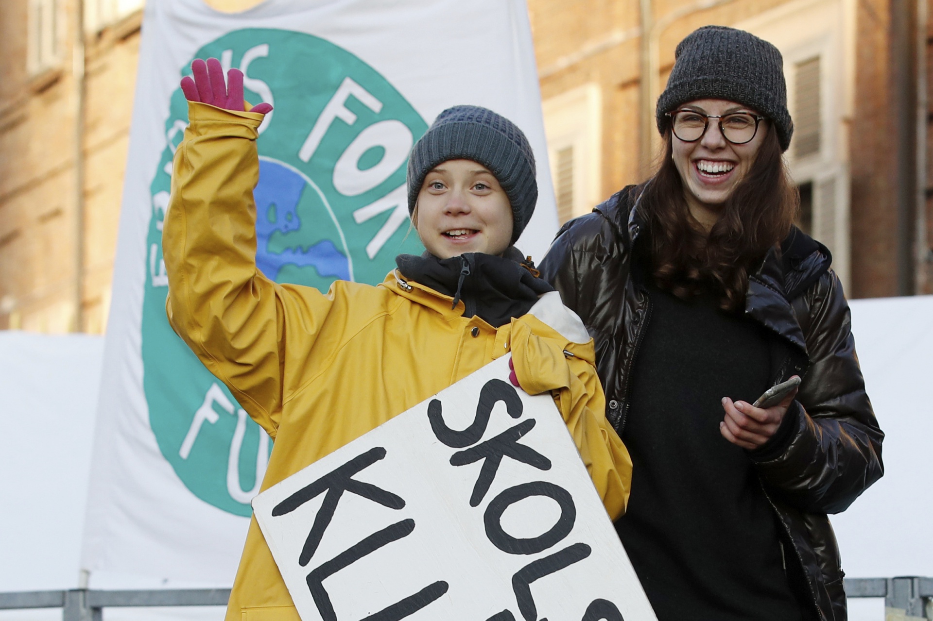 Swedish environmental activist Greta Thunberg holds a sign with writing reading in Swedish, "School strike for the climate" as she attends a climate march, in Turin, Italy