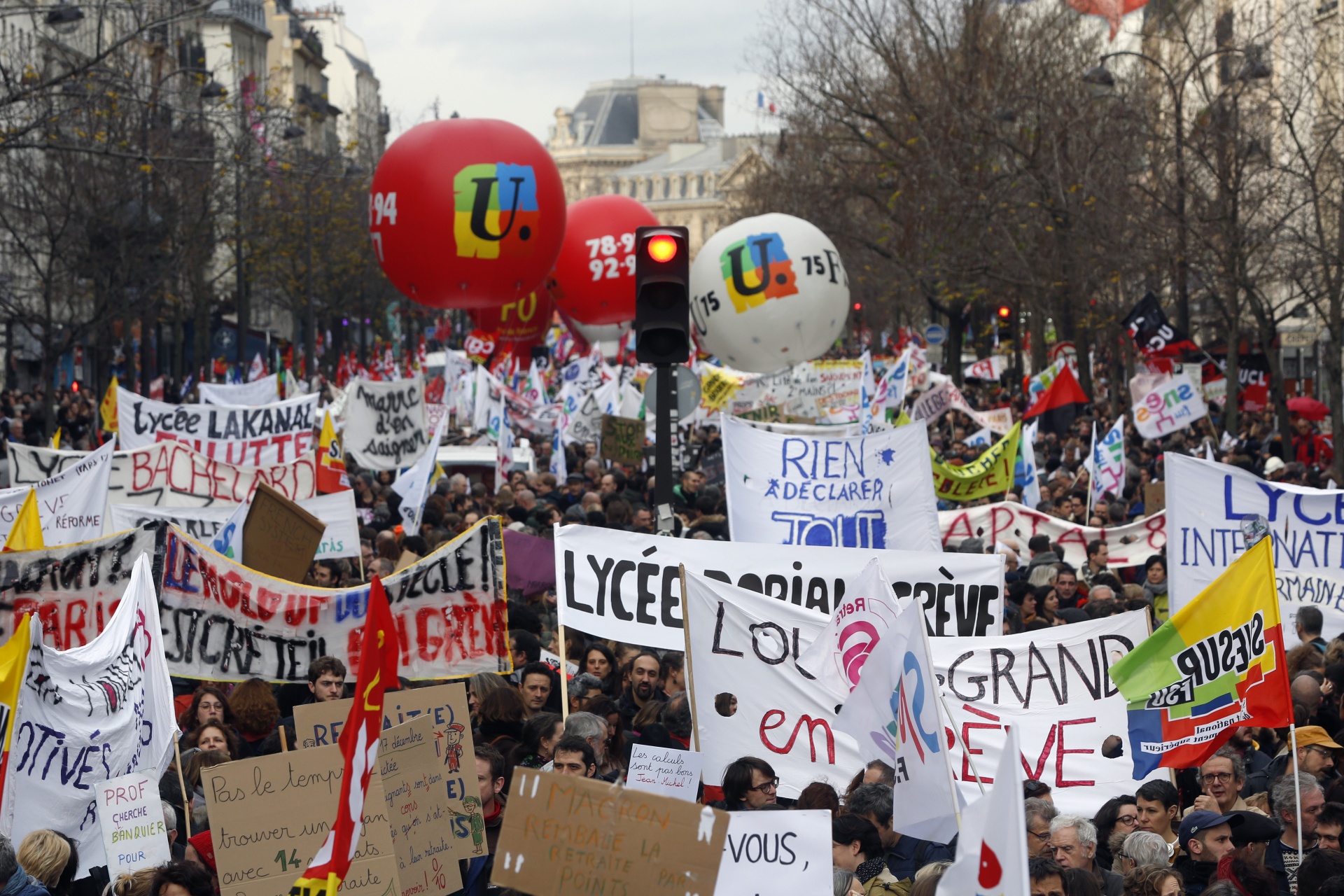 Demonstrators march with banners and union flags during a protest against pension reform plans in Paris
