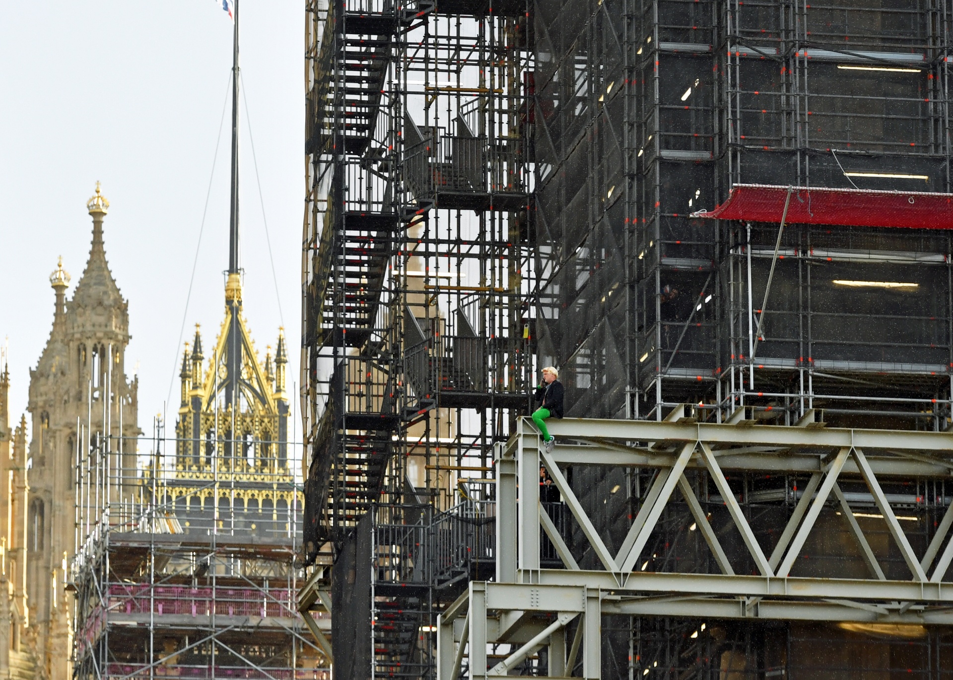 An Extinction Rebellion protester who has scaled the scaffolding surrounding Big Ben is seen without being attached to any ropes at the Houses of Parliament