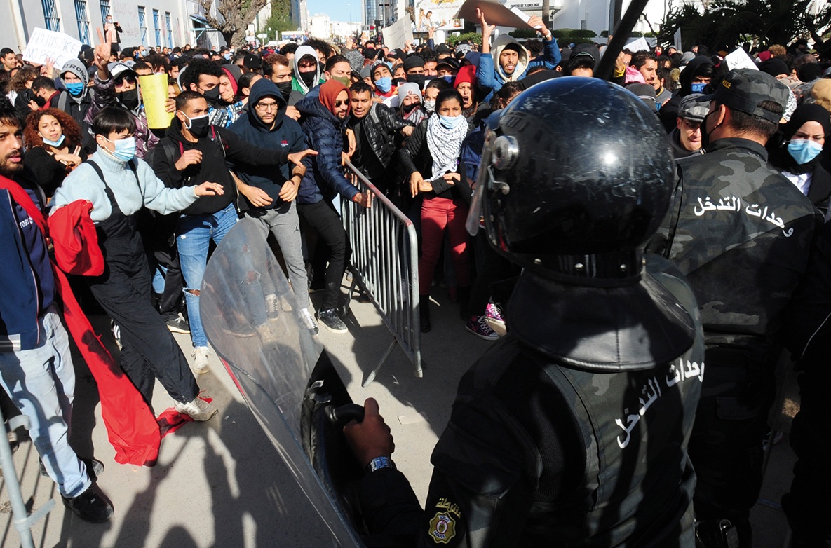 Demonstrators face police in riot gear outside the parliament in the capital Tunis amid days of unrest over poverty and unemployment, during which one young demonstrator died and hundreds were jailed