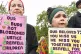 People hold placards at a Grenfell justice protest outside Parliament on May 14