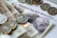 Money stacked on top of an energy bill