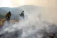 After lighting a fire line to burn up fuel for the Lick Creek Fire, a crew of firefighters begin to put out the flames, July 12, 2021, south of Asotin, Wash. Photo: Pete Caster/Lewiston Tribune via AP