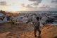 Displaced Palestinians walk through a tent camp in Muwasi, an area that Israel has designated as a safe zone, in Khan Younis southern Gaza Strip, September 25, 2025