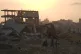 Palestinians walk through the destruction caused by the Israeli military in Sheikh Radwan neighborhood in Gaza City, November 11, 2025
