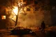 A man walks in front of burning residential building after a Russian attack on Zaporizhzhia, Ukraine, November 26, 2025