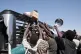Sudanese families displaced from El-Fasher reach out as aid workers distribute food supplies at the newly established El-Afadh camp in Al Dabbah, in Sudan's Northern State, November 16, 2025