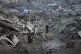 Palestinians walk amid buildings destroyed by Israeli air and ground operations in Gaza City, January 6, 2026