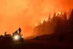 Firefighters stand on a truck as wildfires blaze in El Hoyo, Patagonia, Argentina, late January 8, 2026