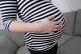 A pregnant woman holding her stomach