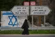 A Palestinian woman walks on the road in the Jordan Valley, West Bank, Monday, Feb. 9, 2026