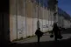 Palestinians walk along the separation barrier between the West Bank and east Jerusalem neighbourhood of Beit Hanina