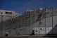 Palestinians walk along the separation barrier between the West Bank and east Jerusalem neighborhood of Beit Hanina, February 15, 2026