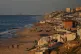 Palestinians walk along the beach next to a tent camp in Deir al-Balah, in the central Gaza Strip, February 25, 2026