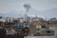 People watch from a rooftop as a plume of smoke rises after a strike in Tehran, Iran, March 1, 2026
