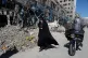 A woman walks past a building which was damaged after a strike on a police station amid the US–Israeli military campaign in Tehran, Iran, March 3, 2026