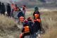 Migrants trying to reach Britain, walk on a beach shore in Gravelines, northern France, March 18, 2026