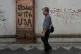 ANTI-IMPERIALIST: A man walks past anti-US graffiti painted on the wall of the British embassy in Tehran