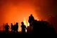 Firefighters and others are silhouetted in front of a wildfire on the outskirts of the northern city of Thessaloniki, Greece, July 4, 2026