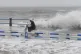 A motorist tries to ride past waves crashing on the shore ahead of Typhoon Bavi in Qingdao in eastern China's Shandong province, July 12, 2026