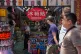 Workers wait for customers at a souvenir shop as foreign tourists walk by Wangfujing shopping street in Beijing, China, July 15, 2026