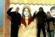 Three Irish volunteers pose in front of a mural depicting Ay