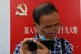 A Chinese citizen takes a selfie outside a Communist Party n