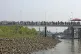 Rohingya refugees walk to a naval vessel to be transported t