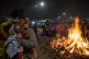 A woman covers a child from the intensity of a bonfire as pr