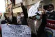 A woman holds a sign reading in Spanish 