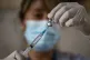 A healthcare worker prepares a dose of the CoronaVac COVID-1