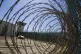 The control tower is seen through the razor wire inside the 