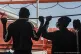 Migrants look at the sea from aboard the Ocean Viking during
