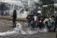 Protesters protect themselves with makeshift shields as they