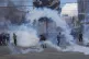 Anti-government coca farmers run away from tear gas fired by