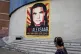 A pedestrian walks near a poster asking for the freedom of C