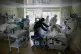 Medics treat a patient with coronavirus (left) as others pre