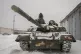 Ukrainian soldiers examine their tank at a military unit clo