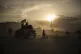 Taliban fighters ride atop a Humvee on the way to detain Afg