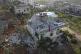 People inspect a destroyed house following a US special forc