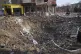People walk past a crater from the explosion in Mira Avenue 